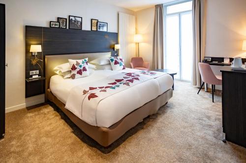 a hotel room with a large bed and a desk at Best Western Plus Monopole Métropole in Strasbourg
