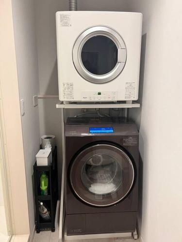 a washing machine with a microwave on top of it at HOKULANI elua in Chōjamachi