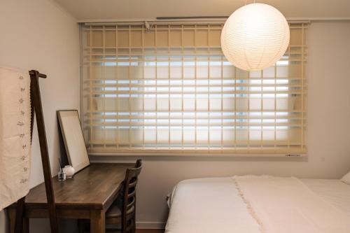 a bedroom with a desk and a window with a lamp at Terastay in Seoul