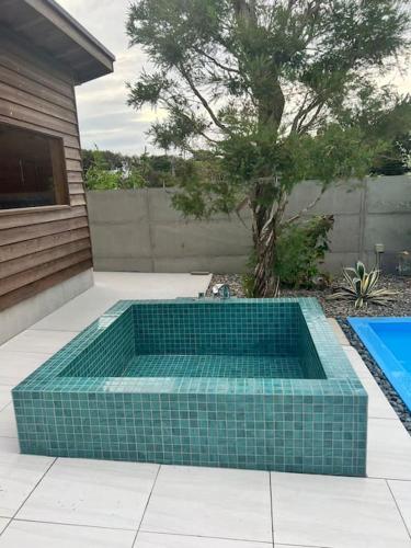 a swimming pool with a blue tiledificialificialificialificialificialificialificialificial at HOKULANI elua in Chōjamachi
