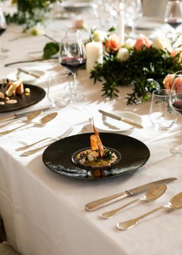 a table with a plate of food on a white table cloth at Relais La Corte dei Papi in Cortona