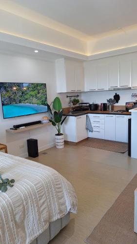 a kitchen with white cabinets and a bed in a room at Luxury Bohemian Suite Venice Canal Mall & BGC Views in Manila