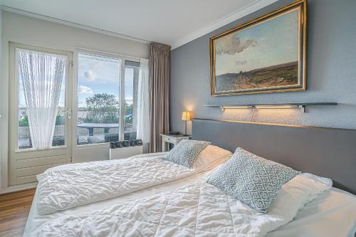 a bedroom with a bed and a large window at Appartementencomplex Juliana 78 in De Koog
