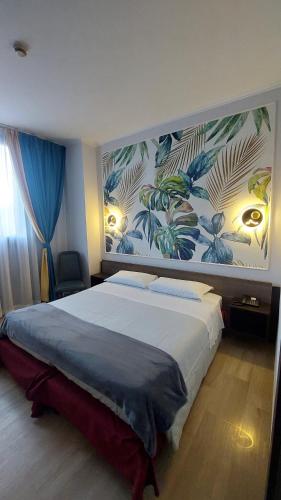 a bedroom with a large bed with a painting on the wall at Eurohotel in Nichelino