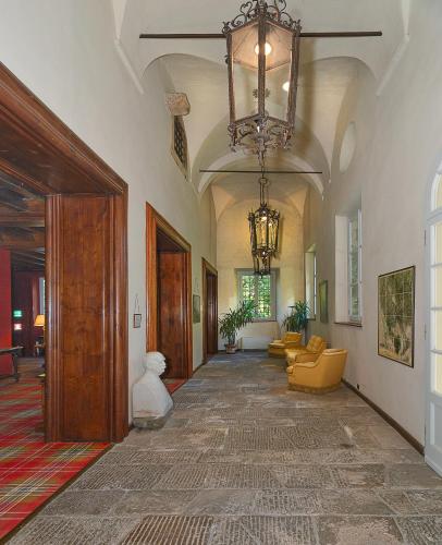 a large hallway with a chandelier and a hallway with couches at Hotel Villa La Principessa in Lucca