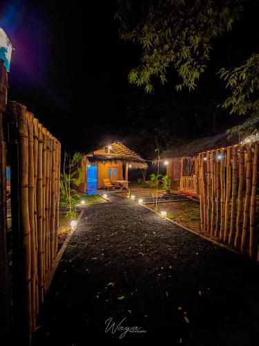 a pathway leading to a house at night at Wild Safari Clay House in Udawalawe