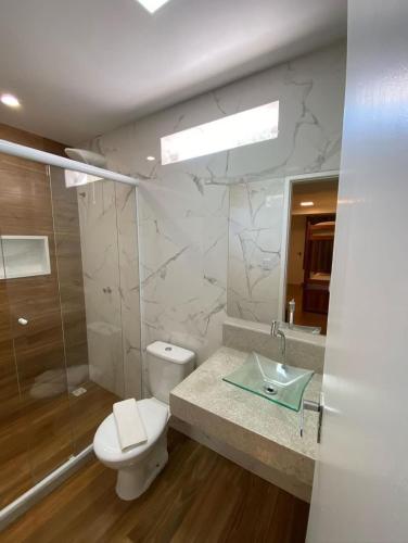 a bathroom with a toilet and a sink and a shower at Lila Limao Hostel in Abraão