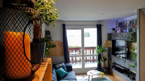 un salon avec un canapé et une plante dans l'établissement Duplex Cosy : Moderne, Fonctionnel et Confortable, à Lans-en-Vercors