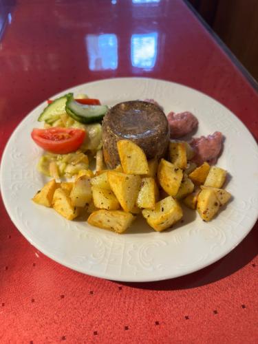 a plate of food with sausage and potatoes on a table at Waldhotel Zöbischhaus in Bad Reiboldsgrün