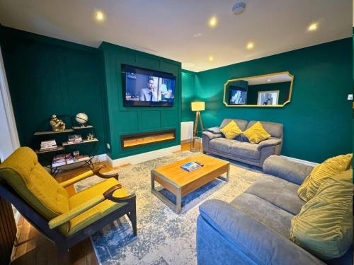 a living room with two couches and a tv at Private All-Weather Hot Tub Apartment, Free Parking, 1 Mile to City Centre, Cafés & Dining Nearby in Jesmond