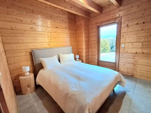 ゾウルツマットにあるDomaine la Clairière Le Chêne Grande maison avec Sauna Terrasse Brasero et baby-footの木造キャビン内のベッド1台が備わるベッドルーム1室を利用します。