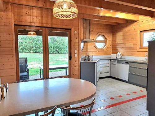 une cuisine avec une table et des chaises dans une cabine dans l'établissement Domaine la Clairière Le Chêne Grande maison avec Sauna Terrasse Brasero et baby-foot, à Soultzmatt