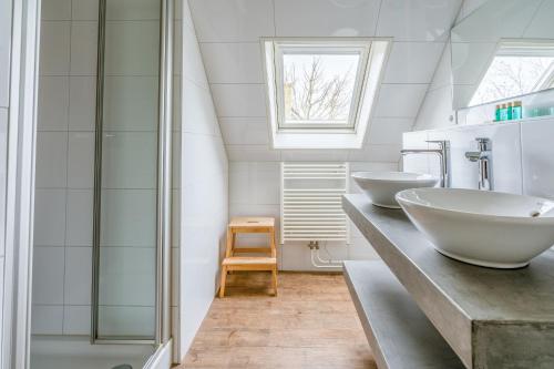 a bathroom with two sinks and a shower at Villapark Kamperfoelie 87 in De Koog