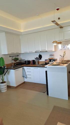 a kitchen with white cabinets and a counter top at Luxury Bohemian Suite Venice Canal Mall & BGC Views in Manila