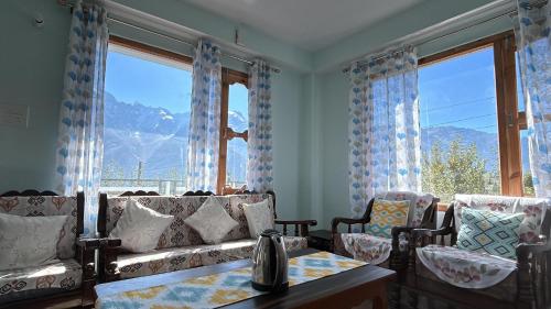 a living room with couches and a table and windows at View Finder in Chini