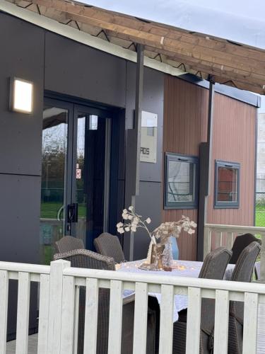 a table with chairs and a vase on it in front of a house at Chalet 3 slaapkamers Oasis 19 in Jabbeke