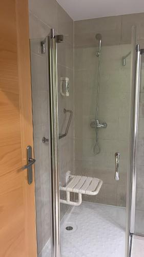 a bathroom with a shower with a bench in it at Hotel 4C Puerta Europa in Madrid