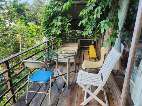 a balcony with chairs and a glass table and a table at Hoi An Mercy homestay in Hiếu Nhơn