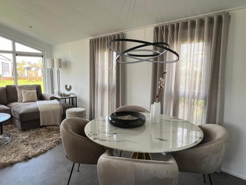 a living room with a glass table and chairs at Qué Vida, Boutique Chalet aan Zee en Meer in Scharendijke