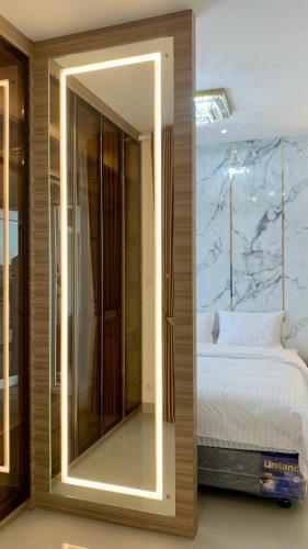a bedroom with a mirror next to a bed at Montage Villa near Beach with Golf View in Nongsa