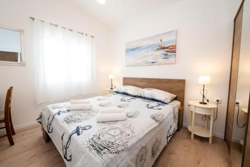 a bedroom with a bed with a white bedspread at Beachfront villa Mihovil with direct beach access in Kastel Stafilic