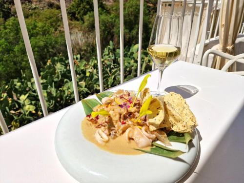 a plate of food on a table with a glass of wine at Historica Casa Juan in Mogán