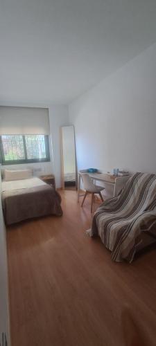 une chambre avec un lit, un bureau et une table dans l'établissement Lovely Room near Park Guell, à Barcelone