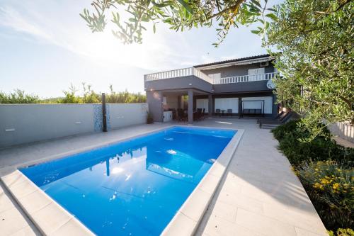 a swimming pool in the backyard of a house at Beachfront villa Mihovil with direct beach access in Kastel Stafilic