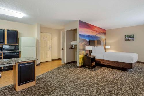 a large hotel room with a bed and a refrigerator at LeConte Hotel & Convention Center, an Ascend Collection Hotel in Pigeon Forge
