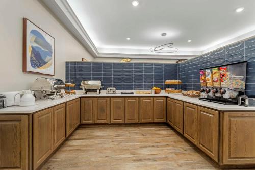a large kitchen with wooden cabinets and blue tiles at LeConte Hotel & Convention Center, an Ascend Collection Hotel in Pigeon Forge
