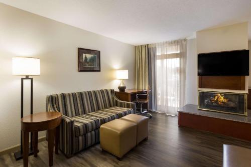 a hotel room with a couch and a fireplace at The Inn at Apple Valley, an Ascend Collection Hotel in Pigeon Forge
