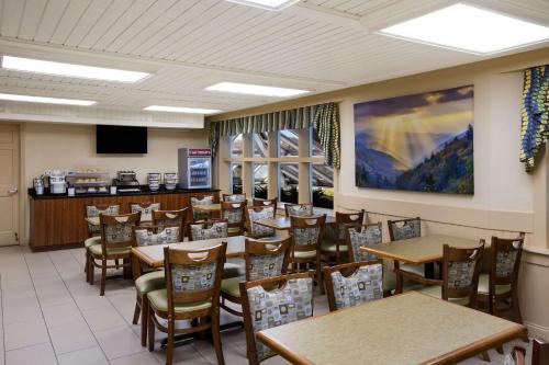 a dining room filled with tables and chairs at The Inn at Apple Valley, an Ascend Collection Hotel in Pigeon Forge
