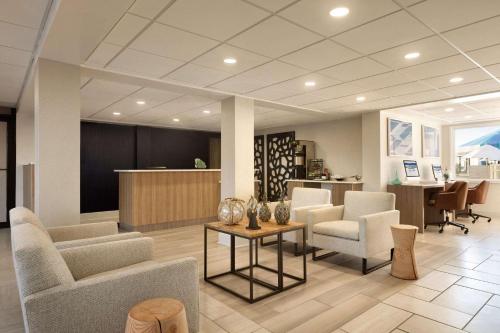 an office lobby with chairs and a table and a counter at Surfbreak Virginia Beach Oceanfront, Ascend Hotel Collection in Virginia Beach