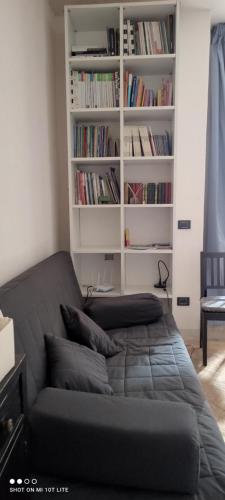 a couch in a living room with a book shelf at Casa Corte - Le Bouganville B&B in Lucera