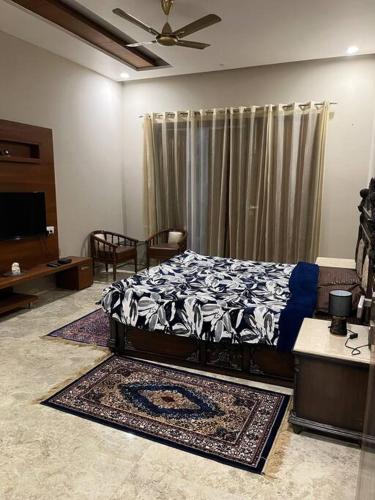 a bedroom with a bed and a tv in a room at VacationBuddy Sukhami Villa, Amritsar in Amritsar
