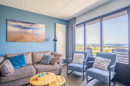 a living room with a couch and two chairs at Appartementencomplex Juliana 156 in De Koog