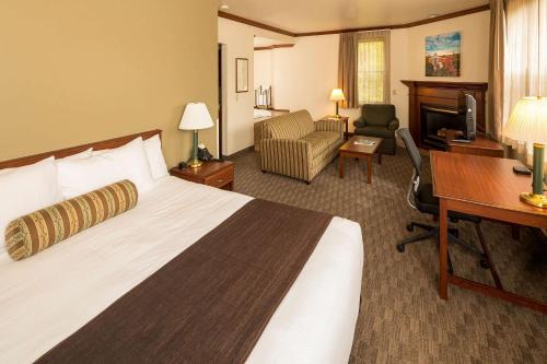 a hotel room with a bed and a desk and a computer at Kress Inn, an Ascend Collection Hotel in De Pere