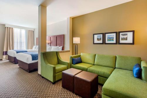 ein Hotelzimmer mit einem Sofa und einem Bett in der Unterkunft Comfort Suites Burlington near I-5 in Burlington
