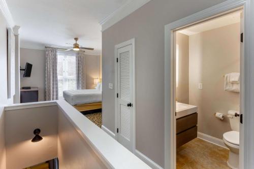 a bathroom with a sink and a toilet and a bed at Church Street Inn Historic Charleston, Ascend Collection Hotel in Charleston