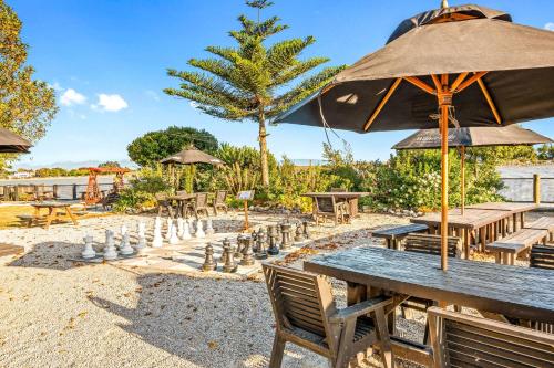 a table and chairs with a chessboard and an umbrella at The Honest Lawyer, an Ascend Collection Hotel in Nelson