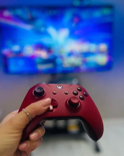 a person holding a red video game controller at Olivina Park Spa - domki z dostępem do krytego basenu, saun, wyżywienia i atrakcji dla dzieci in Niechorze