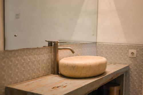 a bathroom sink with a faucet on a counter at Maganda Villa in Tabanan