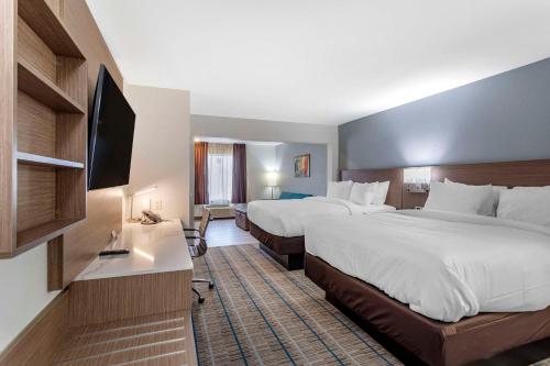 a hotel room with two beds and a flat screen tv at MainStay Suites Lebanon - Nashville Area in Lebanon