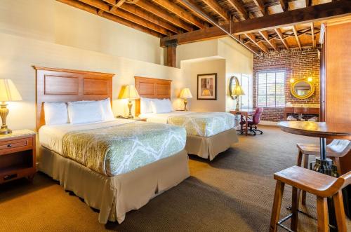 a hotel room with two beds and a table at Jackson Park Inn, an Ascend Collection Hotel in Pulaski