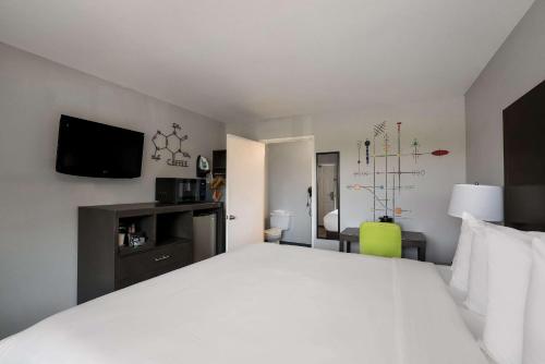 a bedroom with a large white bed and a flat screen tv at Richland Riverfront Hotel, an Ascend Collection Hotel in Richland