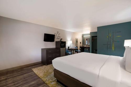 a hotel room with a large bed and a television at Richland Riverfront Hotel, an Ascend Collection Hotel in Richland