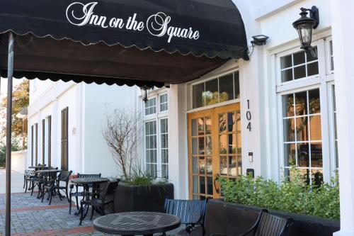 a restaurant with a black awning and tables and chairs at Inn on the Square, an Ascend Collection Hotel in Greenwood