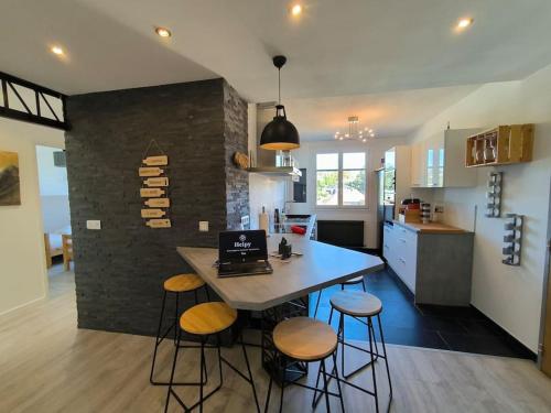 - une cuisine avec une table et des tabourets avec un ordinateur portable dans l'établissement Bel appartement-Foire expo-4 pers-Parking gratuit, à Billère