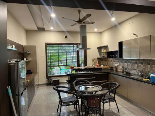 a kitchen with a table and some chairs in it at VacationBuddy Sukhami Villa, Amritsar in Amritsar