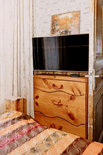 a television sitting on top of a wooden dresser at Rakvere Vanalinna Apartment in Rakvere